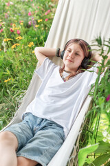 Relaxed teen listening to music in hammock