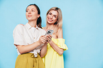Two young beautiful smiling brunette hipster female in trendy summer clothes. Carefree women posing...