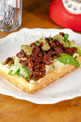 sun dried tomatoes, pesto and iceberg on a belgian waffle