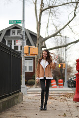 A happy woman standing on a city street and looking straight