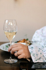 Woman holding wine glass at brunch table