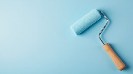 Fototapeta premium Light Blue Background with a Paint Roller Ready for Home Improvement Projects
