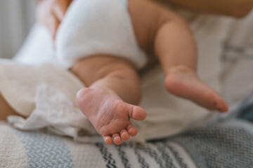 Close-up of a baby's feet wrapped in a white cloth.