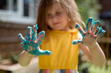 Little girl playing with blue play dough, education and development