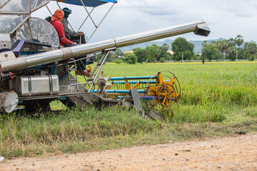 Workers on rice harvester in Thai countryside