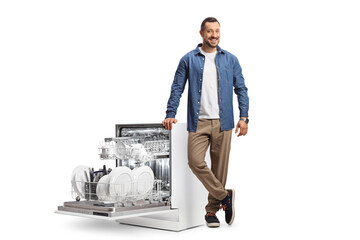 Young man with an open dishwasher loaded with plates