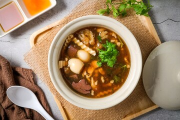 fish maw soup in a white bowl on grey background	