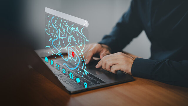 Hands typing on a laptop keyboard with a futuristic digital map interface showing a red location pin, representing online navigation, GPS tracking, digital maps, and real-time geolocation technology.