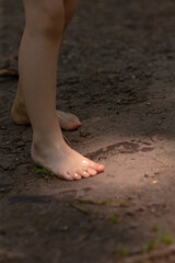 A persons bare feet are firmly standing on a dusty dirt road, connecting them with the earth...