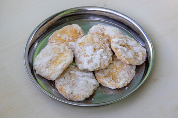 Tasty Khaja sweet on a steel plate with wooden background. This deep-fried pastry soaked in sugar syrup, also known as Gaja or Chiroti, is a popular traditional dessert in Bangladesh and India.