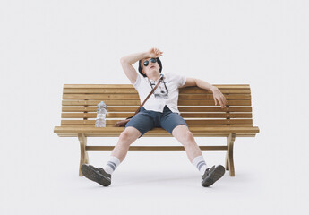 Middle-aged male tourist sitting on a bench, suffering from the heat. Concept of climate change.