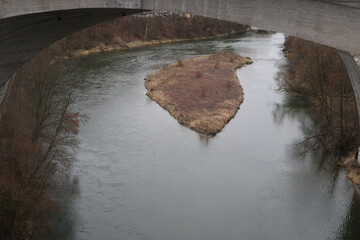A river with a bridge over it and a small island in the middle