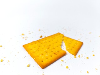 Broken Biscuit on White Background with Crumbs Scattered Around It