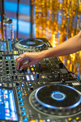 Female DJ Mixing Tracks at Party with Gold Backdrop