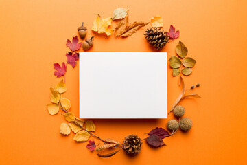 Autumn composition with paper blank and dried leaves on table. Flat lay, top view, copy space