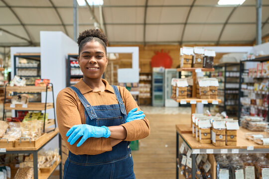 Confident african american saleswoman smiling with crossed arms in zero waste store