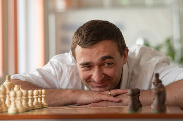 Middle aged Caucasian man playing chess. 