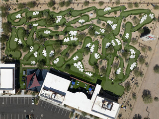 Aerial view of a vibrant miniature golf course with winding green fairways, white sand traps, and colorful buildings, Scottsdale, Arizona, United States.