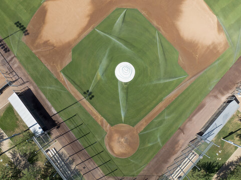 Aerial view of a baseball field with sprinklers watering the lush green grass and contrasting brown dirt, Scottsdale, Arizona, United States.