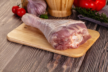 Raw turkey drumstick leg over board