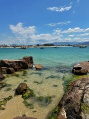 Crystal clear turquoise water on a tropical beach with a fishing village in the background.
