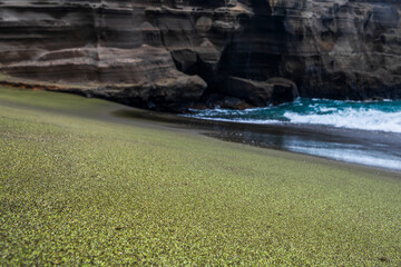Scenic view of Green Sand Beach on Hawaii’s Big Island, featuring rare olive-green sand and...