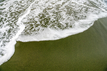 Scenic view of Green Sand Beach on Hawaii’s Big Island, featuring rare olive-green sand and...