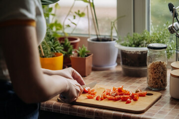 Woman slicing cherry tomatoes on cutting board