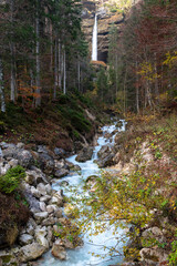 Waterfall flowing in the valley. Turquoise water flows through a rocky riverbed. Slovenia.