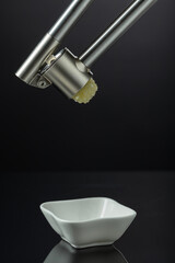 Garlic press on a black background.