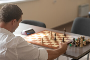 Middle aged Caucasian man playing chess. 