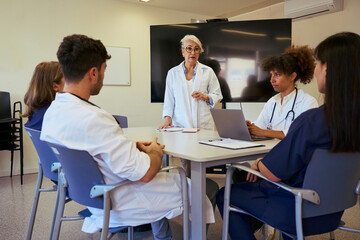 Medical team meeting discussing patient care in modern hospital