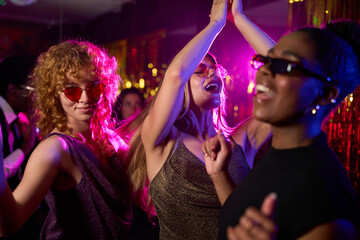 Young women dancing and enjoying nightlife in disco club
