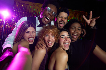 Cheerful friends taking selfie at nightclub party
