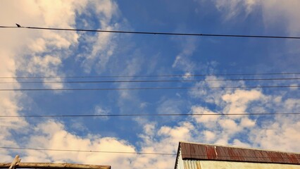 Powerlines on air with blue sky and clouds background