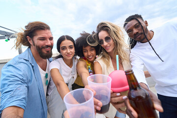 Friends toasting drinks at rooftop party, celebrating friendship