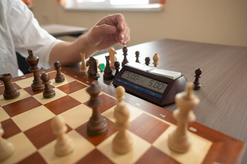 Close up of hands of middle aged caucasian man playing chess. 