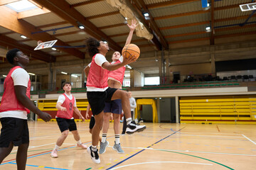 Basketball players jumping for ball during training