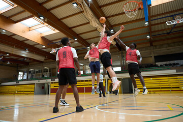 Basketball players jumping for the ball during training