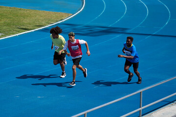 Athletes running on blue track during competition