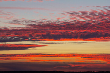 Vibrant sunset over the horizon displaying hues of orange red and purple against a clear sky in a...