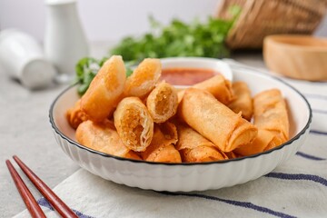 Deep fried vegetable spring rolls or egg rolls and sauce , Thai called popia in white  plate on grey background	