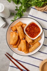 Deep fried vegetable spring rolls or egg rolls and sauce , Thai called popia in white  plate on grey background	