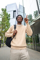 Young professional pointing up in urban setting