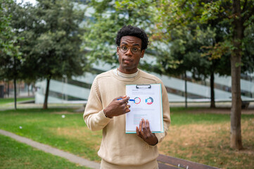 Fototapeta premium Analyst showcasing charts on clipboard in a park