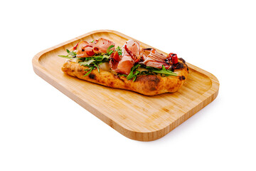 Delicious flatbread topped with fresh greens and cured meats on a wooden platter