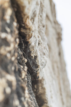 View of rough, aged stone with varied textures, colors, and deep crevices, evoking a sense of history and timelessness, Paphos, Paphos, Cyprus.