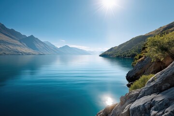 Fototapeta premium Serene mountain lake landscape with clear blue sky and sunlight reflection
