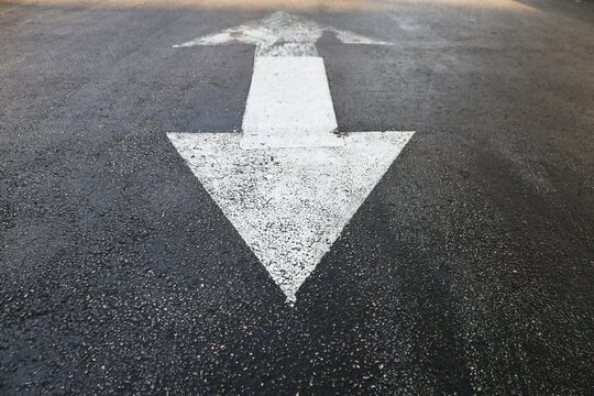 Two sides triangle arrow sign on the road asphalt