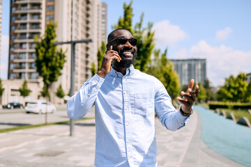 Businessman engages in lively conversation outdoors in a modern urban setting, featuring tall...
